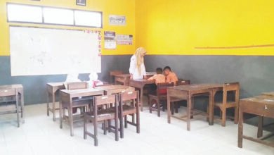 Seorang guru di salah satu SD Negeri di Kabupaten Demak menemani siswanya belajar pada awal masa sekolah. Menunjukkan bahwa SDN di Demak kekurangan siswa baru. (Lingkartv.com)